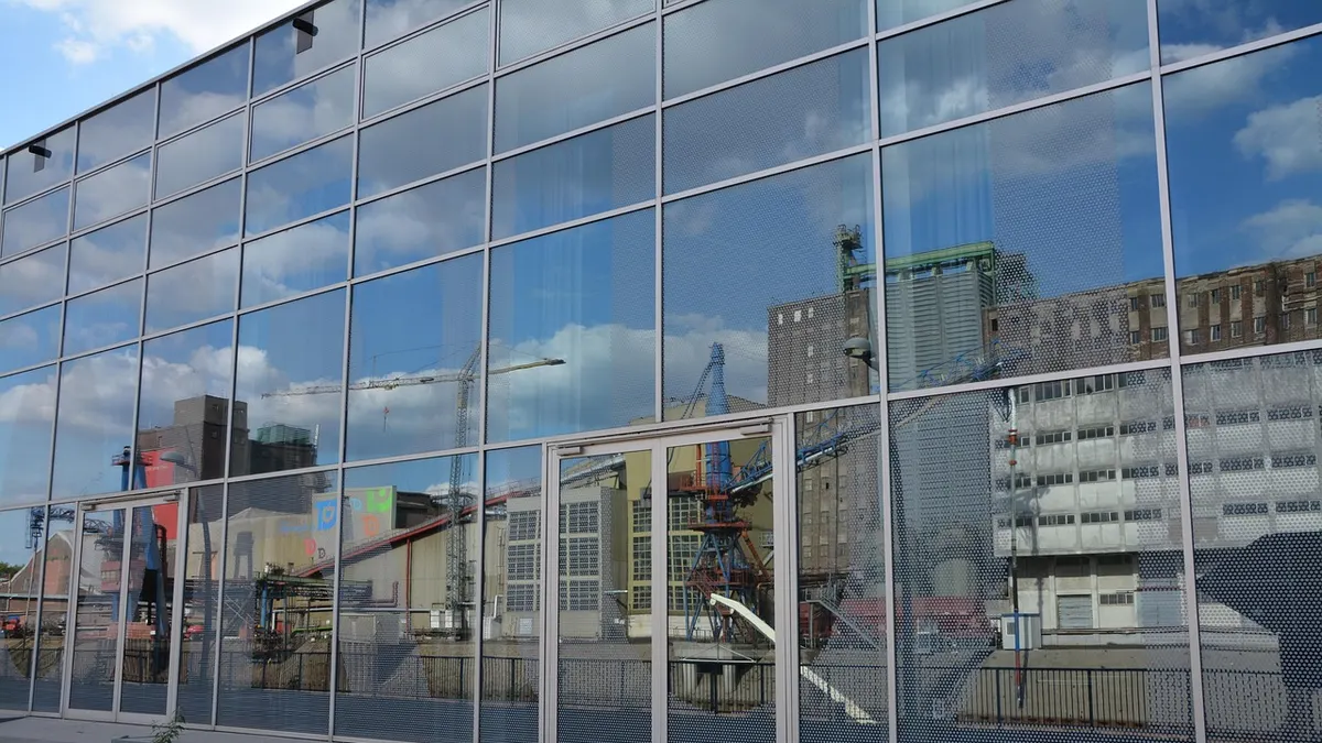 Fachada envidraçada de prédio refletindo o entorno